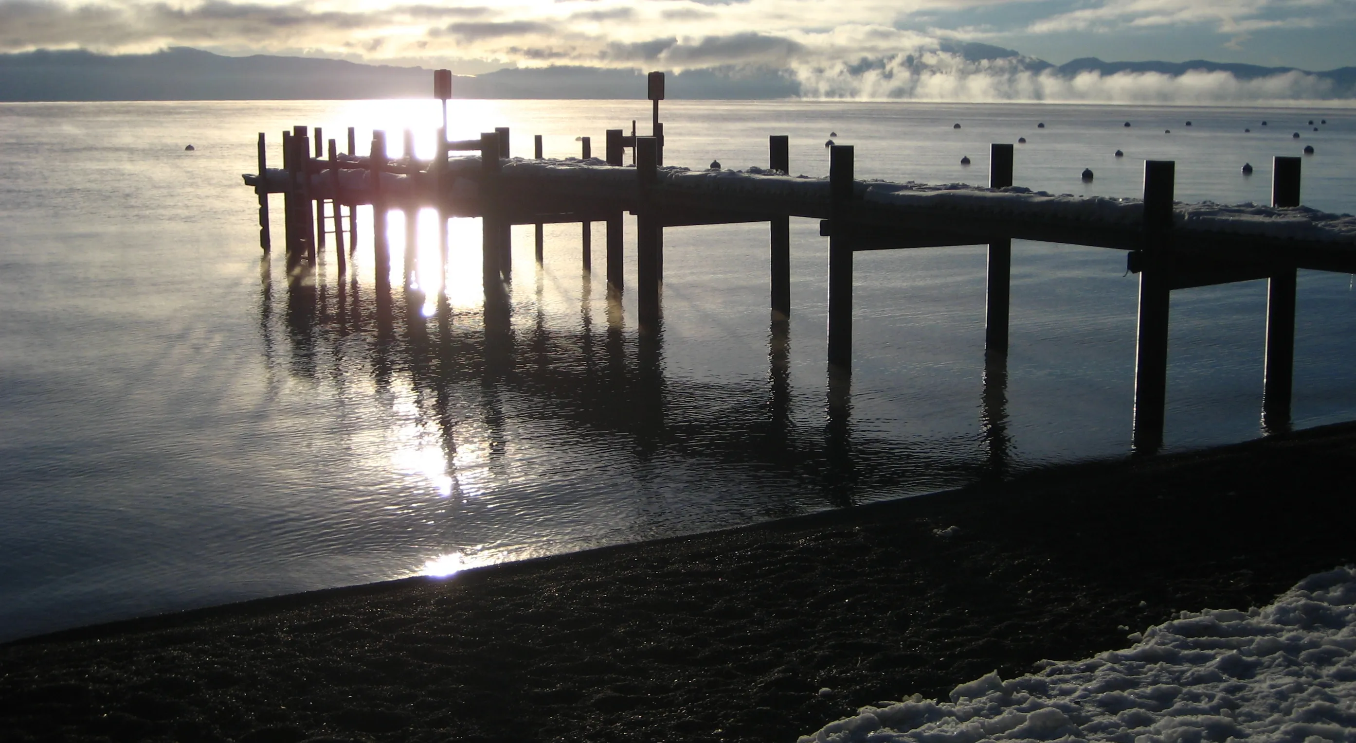 An icy pier reaching into Lake Tahoe at Sunnyside on a gray winter day